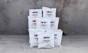 Pila de bolsas blancas de Microfibra de Polipropileno PSI de 600 g, apiladas contra una pared de concreto, con etiquetas que indican "Microfibra Polipropileno 19 mm" y el logo de PSI en rojo y negro.