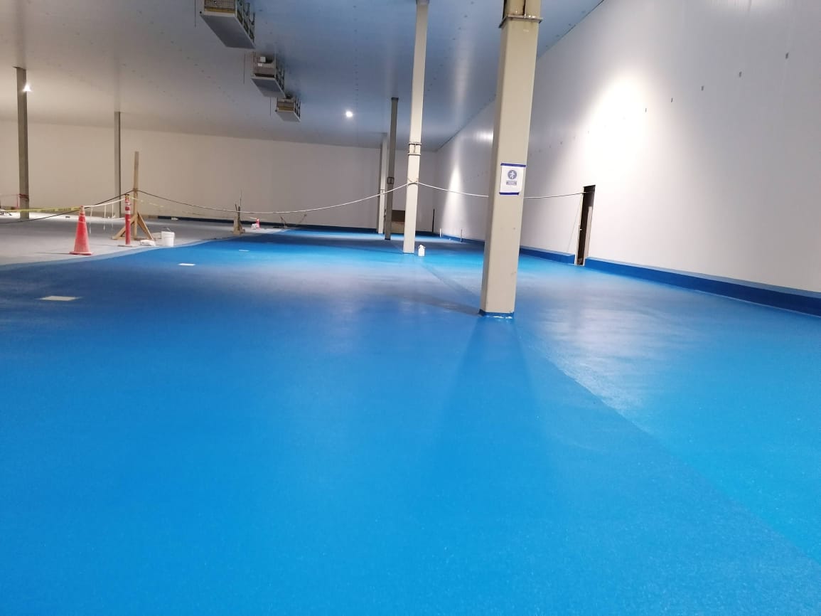 Piso de uretano de color azul en superficie industrial amplia